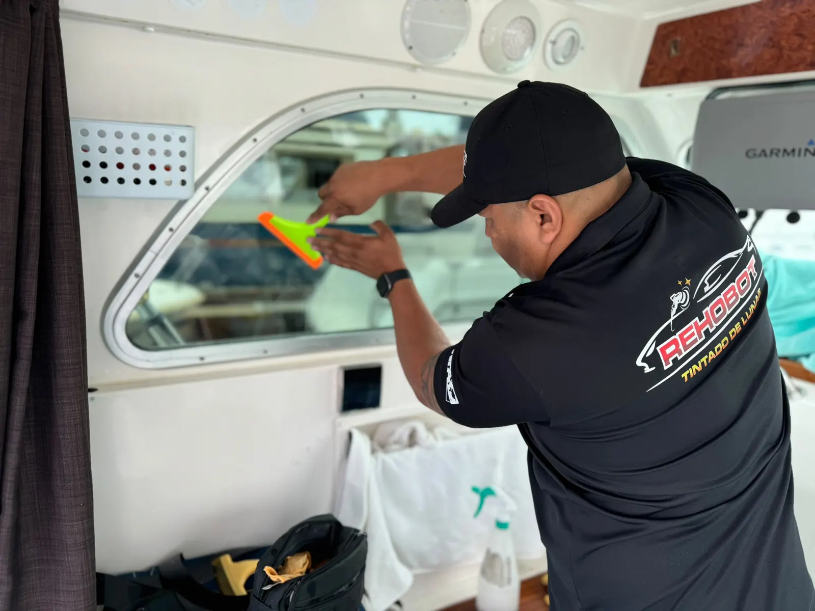 Instalador de Rehobot aplicando lámina de polarizado en una ventana