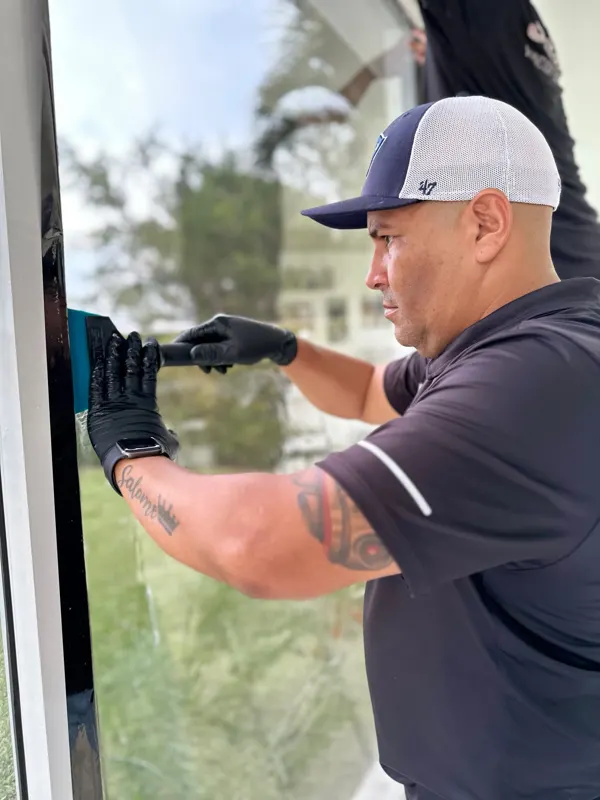 Instalador aplicando película en una ventana